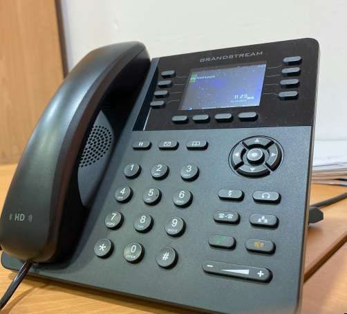 Telefone IP empresarial numa secretária
